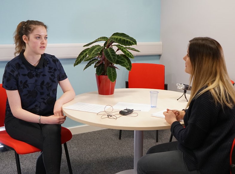 A research interview taking place in a meeting room.